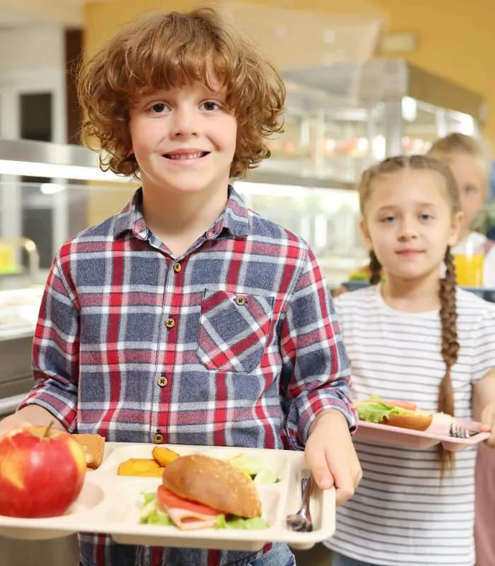 kids with lunch trays in a school cafeteria